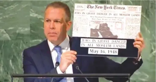  ?? (Israel at the UN) ?? DURING A debate in the General Assembly, in November, UN Ambassador Gilad Erdan holds up the headline story from ‘The New York Times,’ from May 1948, which warns of the grave danger facing Jews in Muslim lands.
