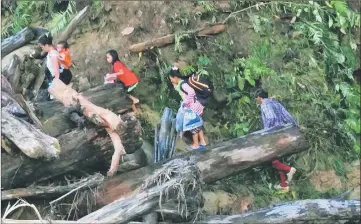  ??  ?? The people have to walk along river banks to get to the other side of the collapsed bridge at Sg Keluan.