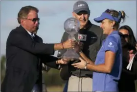  ?? LUKE FRANKE — NAPLES DAILY NEWS VIA AP ?? LPGA Tour pro Lexi Thompson is awarded the CME Globe season trophy after the final round of the CME Group Tour Championsh­ip at TiburÃ3n Golf Club, Sunday in Naples, Fla.