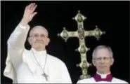  ?? ALESSANDRA TARANTINO — ASSOCIATED PRESS ?? Pope Francis, left, waves from the main balcony of St. Peter’s Basilica at the Vatican on Christmas. At right is Bishop Guido Marini.