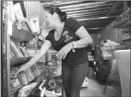  ?? AP/LYNNE SLADKY ?? Mariela Reyes, a volunteer with Venezuelan Roots, sorts donated goods for newly arrived Venezuelan immigrants at Value Store It in Doral, Fla. Many of the Venezuelan­s now seeking food and other assistance in South Florida were once profession­als or...