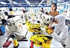  ??  ?? Workers attend a production line at a shoe factory in Tangerang, Indonesia. Many US manufactur­ers are leaving China in favour of Southeast Asia and Mexico.