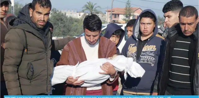  ?? — AFP ?? KHAN YUNIS: A man buries his child who was killed in overnight Zionist air strikes on the Muammar home, at a cemetery in east Khan Yunis in the southern Gaza Strip on Feb 26, 2024.