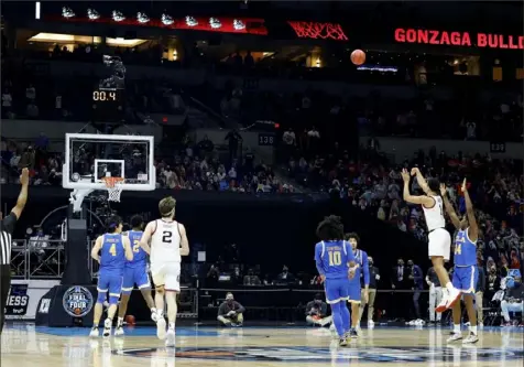  ?? Getty Images ?? Gonzaga’s Jalen Suggs, right, shoots the winning 3-pointer to beat UCLA, 93-90, in overtime Saturday night in Indianapol­is.