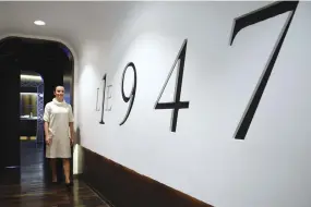  ??  ?? A WAITRESS poses next to the logo of the three-star restaurant Le 1947 run by French chef Yannick Alleno at the five-star palace hotel Cheval Blanc in the French Alps ski resort of Courchevel on Feb. 10. Courchevel is a magnet for the internatio­nal...