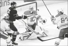  ?? ASSOCIATED PRESS ?? OTTAWA SENATORS LEFT WING AUSTIN WATSON (16) gets his stick on a flying puck as Calgary Flames goaltender David Rittich (33) keeps an eye on it during second period NHL action in Ottawa on Monday.