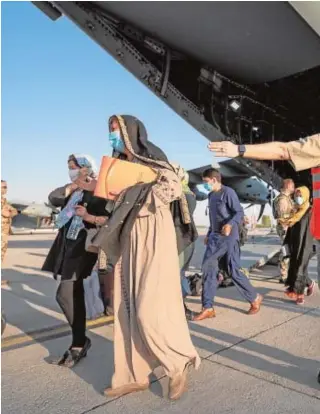  ?? // REUTERS ?? Evacuados afganos salen de un avión alemán en Tashkent