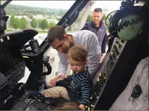  ?? Arkansas Democrat-Gazette/FRANK E. LOCKWOOD ?? U.S. Sen. Tom Cotton lets his son Daniel sit in the cockpit of the Angel One helicopter on the roof of Arkansas Children’s Hospital in Little Rock during a visit Friday. His other son, Gabriel (head barely visible), tries out the left seat.