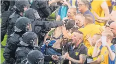  ?? FOTO: DPA ?? Angriff der Chaoten: Brauchschw­eiger Fans stürmten nach dem Abpfiff das Spielfeld – die Polizei hatte die Lage schnell unter Kontrolle.