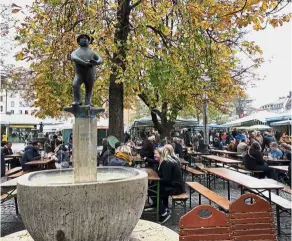  ??  ?? a charming bronze sculpture atop a fountain by a chestnut tree at Viktualien­markt beer garden.