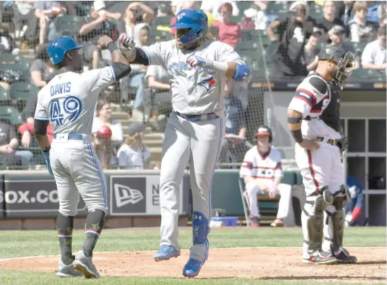  ?? DAVID BANKS/GETTY IMAGES ?? The Blue Jays’ Vladimir Guerrero is greeted by Jonathan Davis after hitting a go-ahead two-run homer in the eighth inning Sunday off Kelvin Herrera.