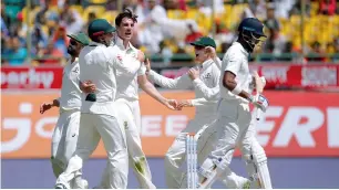  ?? Reuters ?? Pat Cummins celebrates with his teammates after dismissing Lokesh Rahul. —