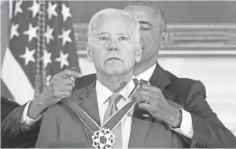  ?? MICHAEL REYNOLDS, EUROPEAN PRESSPHOTO AGENCY ?? President Obama decorates Vice President Biden in the White House on Thursday. “I had no inkling,” Biden said later.