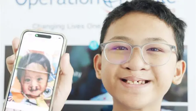  ?? PHOTOGRAPH COURTESY OF WATSONS ?? JAMAL Nathan Daisanta, 11, holds up a photo on his mobile phone of himself 10 years ago. He was among the first patients operated on under the Operation Smile-Watsons Philippine­s partnershi­p. A total of 2,300 have since received free surgery.