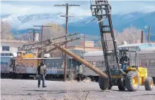  ??  ?? Kim Bartell, left, an engineer with the Santa Fe Southern Railway, and Bob Sarr, owner of Santa Fe Railway, remove railroad poles in the Railyard in 2006, before the groundbrea­king ceremony.