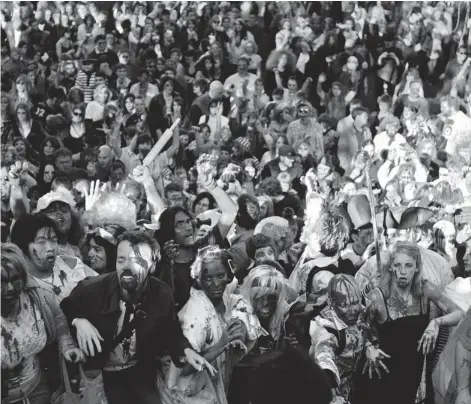  ?? TYLER ANDERSON/ NATIONAL POST ?? A crowd of people dressed as zombies participat­e in the Toronto Zombie Walk. Toronto is also home to a 5K run with zombies chasing humans.