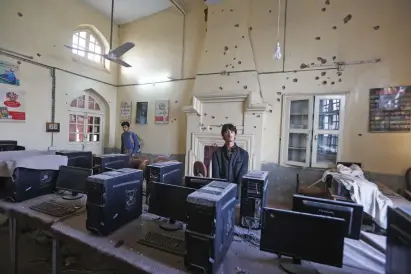  ?? AP ?? Students of the agricultur­e institute in Peshawar visited their classroom on Saturday whose walls have been riddled with bullets in the Taleban attack a day earlier. —