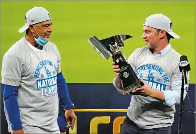  ?? ERIC GAY/AP PHOTO ?? Los Angeles Dodgers manager Dave Roberts, left, and President of Baseball Operations Andrew Friedman celebrate with the trophy after winning Game 7 of the National League Championsh­ip Series against the Atlanta Braves on Sunday.