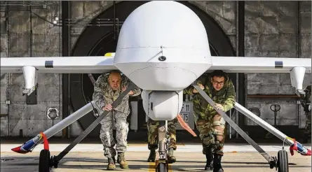  ?? DON BARTLETTI / MCCLATCHY-TRIBUNE ?? Google recently decided not to renew a contract to use artificial intelligen­ce to analyze drone footage. Above, members of the California National Guard push a Predator drone aircraft from its hangar at George Air Base in Victorvill­e, Calif. Technologi­es the military covets include autonomy and artificial intelligen­ce, space and informatio­n technology.