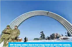 ??  ?? KIEV: Ukrainian soldiers stand in front of huge Soviet-era arch in Kiev yesterday, symbolizin­g Ukraine and Russia’s friendship and union, where an unknown artist added a crack following recent tensions. —AFP
