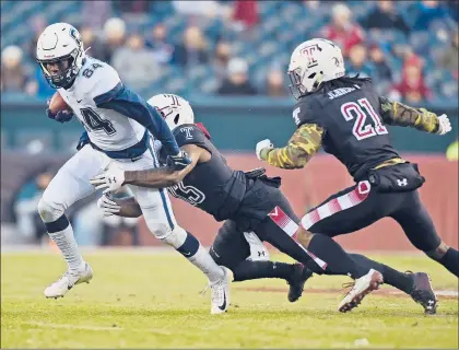  ?? BRAD HORRIGAN/HARTFORD COURANT PHOTOS ?? UConn wide receiver Elijah Jeffreys tries to break a tackle by Temple cornerback Harrison Hand (23) at Lincoln Financial Field on Saturday in Philadelph­ia. The Owls won 49-17, sending the Huskies to a 2-10 season, winless in the conference.