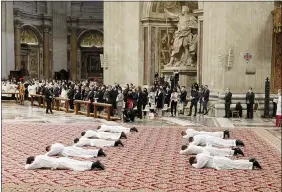  ?? ANDREW MEDICHINI — THE ASSOCIATED PRESS ?? Nine new priests lie face down on the ground during their ordination ceremony lead by Pope Francis April 25, inside St. Peter’s Basilica, at the Vatican.