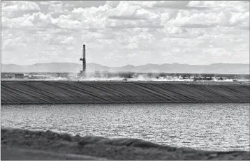  ?? CALLAGHAN O’HARE/BLOOMBERG ?? A WaterBridg­e rig operates behind a Colgate Energy fracking pond in Reeves County, Texas.