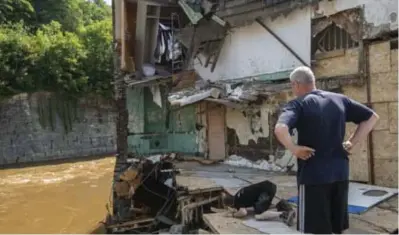  ??  ?? Een bewoner komt de schade opmeten aan zijn huis.