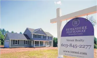  ?? CHARLES KRUPA/AP ?? A for-sale sign in front of a newly constructe­d home in Auburn, New Hampshire, in June.