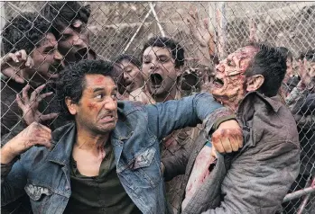  ?? AMC ?? Cliff Curtis and zombies from season 3 of Fear the Walking Dead, which begins with his character, Travis, showing violent characteri­stics.