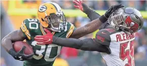  ?? NETWORK-WISCONSIN WM. GLASHEEN/USA TODAY ?? Packers running back Jamaal Williams stiff-arms Tampa Bay Buccaneers middle linebacker Kwon Alexander in overtime Sunday at Lambeau Field. The Packers won, 26-20, boosted by Williams’ 113 yards rushing.