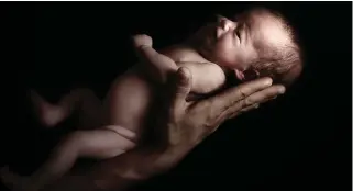  ??  ?? SO CUTE: A tiny newborn baby girl rests on her father’s hand