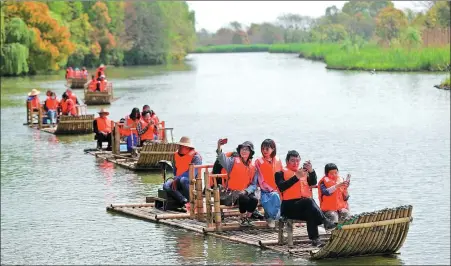  ?? WANG ZHENG / FOR CHINA DAILY ?? Tourists ride on bamboo rafts at the Xiazhu Lake National Wetland Park in Deqing, Zhejiang province, on April 5.