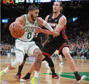  ?? MATT STONE / HERALD STAFF FILE ?? RIVALRY WARMING BACK UP: Miami Heat forward and former Celtic Kelly Olynyk (right) defends against Celtics forward Jayson Tatum on Dec. 4.