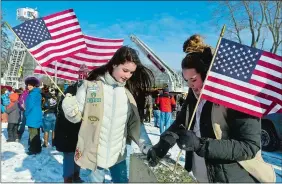  ??  ?? Above, Girl Scout Cadettes Lindsay Davies, left, and Emma Hundley, both with Troop 63100 of Ledyard, clean snow off a grave before a Wreaths Across America Day ceremony on Saturday at Jordan Cemetery in Waterford.
Left, Taps is played during the...