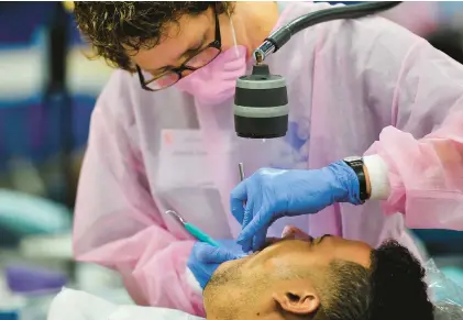  ?? CHRIS POST/SPECIAL TO THE MORNING CALL ?? A volunteer works at a previous free dental clinic at the Allentown Fairground­s.