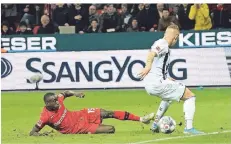  ?? FOTO: IMAGO IMAGES ?? Moussa Diaby kommt im Zweikampf mit Freiburgs Jonathan Schmid auf dem rutschigen Rasen der BayArena zu Fall.