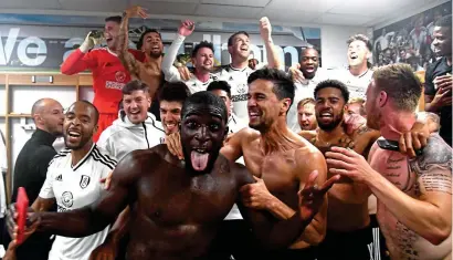  ??  ?? Party time: Aboubakar Kamara leads the celebratio­ns in the Fulham dressing room