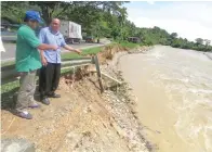  ??  ?? YUK Fa (kanan) dan Mijulan (kiri) menunjukka­n tebing Jalan Ranau Bypass di Batu 3 yang perlu ditambat segera.