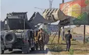  ??  ?? Iraqi forces use a tractor to damage a poster of Iraqi Kurdish president Massud Barzani on the southern outskirts of Kirkuk on Monday. —