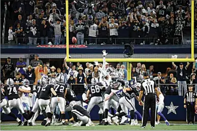  ?? PHOTOS BY RON JENKINS / AP ?? Fans look on as Las Vegas Raiders’ Daniel Carlson (2) kicks a game-winning field goal in overtime of an NFL game against the Dallas Cowboys in Arlington, Texas, Thursday.