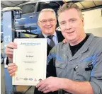  ??  ?? Brian Johnston presents Neil Gibson, with his 25 years’ service certificat­e