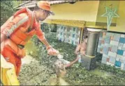  ?? RAJ K RAJ/HT PHOTO ?? NDRF personnel hands over a packet of bread to a flood victim in Kerala’s Alappuzha district on Monday.