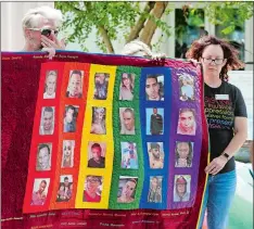  ?? JOE BURBANK ORLANDO SENTINEL VIA AP ?? Douglas Barrett, left, and Rev. Shelly Denmark, with others, hold a memorial quilt during the tolling of the bells and reading of the names at First United Methodist Church in Orlando, Fla., Wednesday.