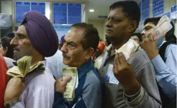  ?? NARINDER NANU/AFP/GETTY IMAGES ?? Indians stand in line to deposit and exchange discontinu­ed currency notes outside a bank in Mumbai on Thursday.