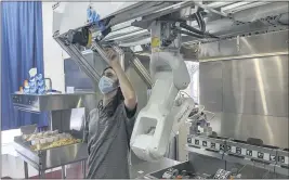  ?? MISO ROBOTICS ?? A technician makes an adjustment to a robot at Miso Robotics’ White Castle test kitchen in Pasadena on Thursday.