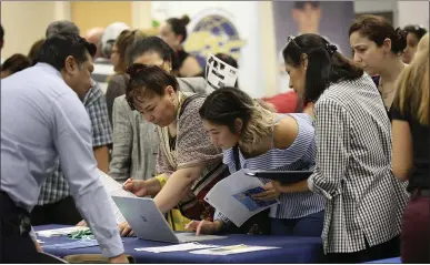  ?? LYNNE SLADKY — ASSOCIATED PRESS ARCHIVE ?? Applicants look through available positions during a recent job fair in Miami. Topping Glassdoor’s best jobs for 2020 are front-end engineers, which are web developers or designers who choose, install and test a website’s user interface elements.