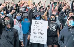  ?? AFP ?? Supporters at the Louisville Metro Hall raise their fists in protest of the lack of criminal charges in the police killing of Breonna Taylor.