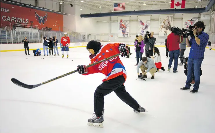  ?? — PHOTOS: JOHN MACDONNELL/WASHINGTON POST ?? Fatima Al Ali takes some one-timers with a stick used by Washington Capitals forward T.J. Oshie while a flock of reporters filmed it all.