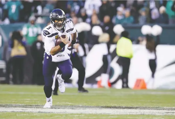  ?? ROB CARR/GETTY IMAGES ?? Seahawks QB Russell Wilson runs for a first down during a win over the Eagles in playoff action back in January. Seattle returns to Philly for a rematch on Nov. 30.